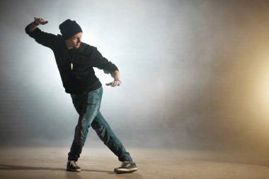 adam çapraz bacakları ve yükseltilmiş el hareketleri hip hop yapıyor