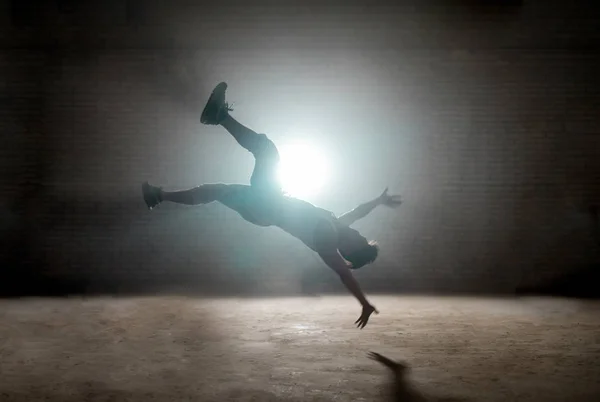 Bailarina haciendo acrobacias en el aire, haciendo telón de fondo en el suelo —  Fotos de Stock