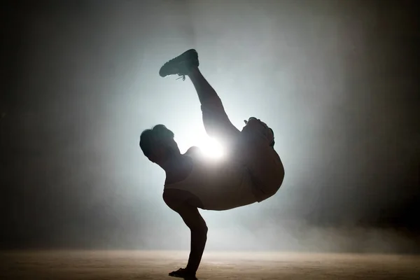 Homem com cabelos escuros aprendendo acrobacias básicas de breakdance fora — Fotografia de Stock