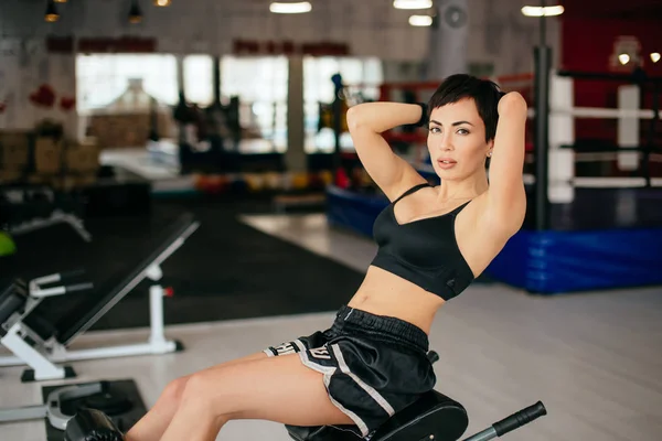 Impressionnant mince femme faisant assis sur le banc de presse à l'intérieur — Photo