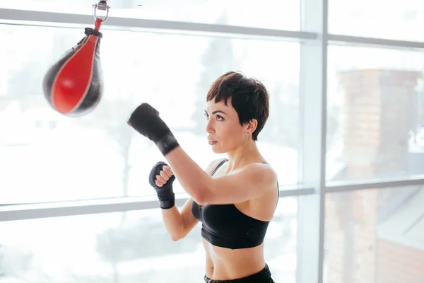 Mujer musculosa en vendajes de boxeo y peras en el estudio —  Fotos de Stock