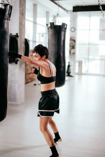 Vista lateral vertical imagen de la mujer en forma que participa en el evento deportivo de boxeo —  Fotos de Stock