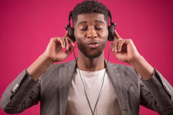 Joven africano macho usando auriculares es enojado con la música — Foto de Stock