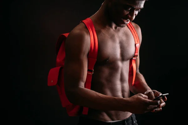 Abgeschnittene Seitenansicht Porträt eines jungen Schwarzen, der sein Handy zur SMS benutzt. — Stockfoto