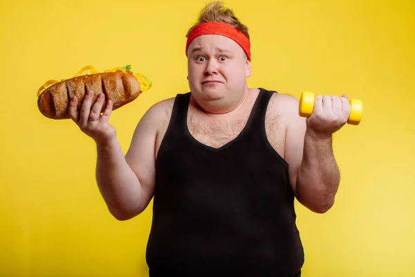 Fat man choise between sport and fastfood — Stock Photo, Image