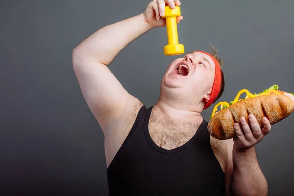 Zabawny facet w sportowej jeść małe hantle — Zdjęcie stockowe