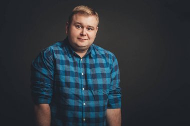 Kafkasyalı şişman adam kameraya bakıyor.