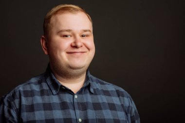 Siyah arka planda gülümseyen şişman adam