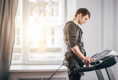 Ems eğitim salonunda treadmill çalışan siyah elbiseli adam