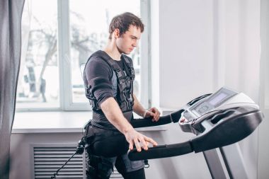 Ems eğitim salonunda treadmill çalışan siyah elbiseli adam
