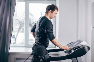 Ems eğitim salonunda treadmill çalışan siyah elbiseli adam