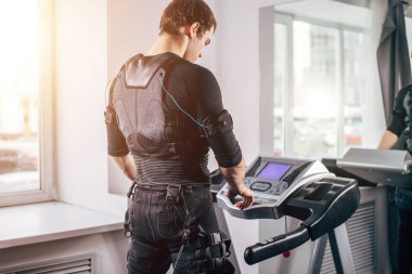 Ems eğitim salonunda treadmill çalışan siyah elbiseli adam