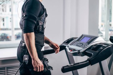 Ems eğitim salonunda treadmill çalışan siyah elbiseli adam