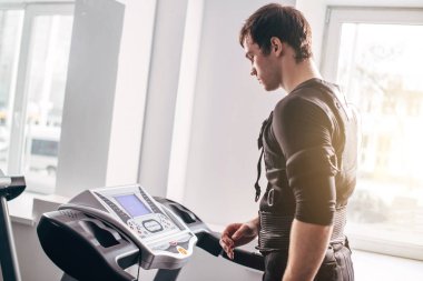Ems eğitim salonunda treadmill çalışan siyah elbiseli adam