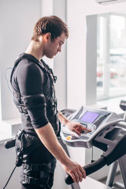 Ems eğitim salonunda treadmill çalışan siyah elbiseli adam