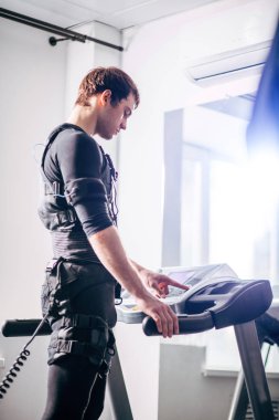 Ems eğitim salonunda treadmill çalışan siyah elbiseli adam