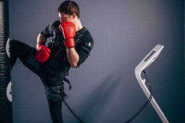 adam eğitim diz vuruş. Elektrik stimülasyon takım elbise giyen bir kick boks