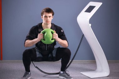 Medecine topu eğitim ile uyarmak için elektrik kas elbiseli adam