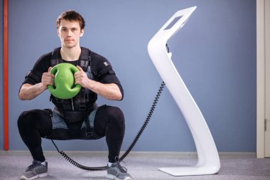 Medecine topu eğitim ile uyarmak için elektrik kas elbiseli adam