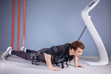 Ems erkek itme yapıyor ups içinde elektrik kas Stimülatörü bağlıyken jimnastik salonu