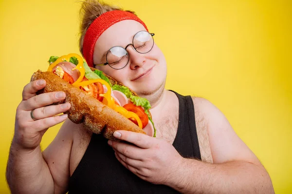 Śmieszne człowiek przytula a ogromny burger — Zdjęcie stockowe