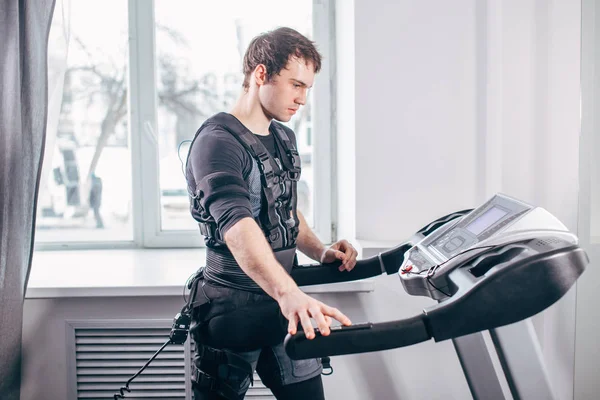 Ems eğitim salonunda treadmill çalışan siyah elbiseli adam