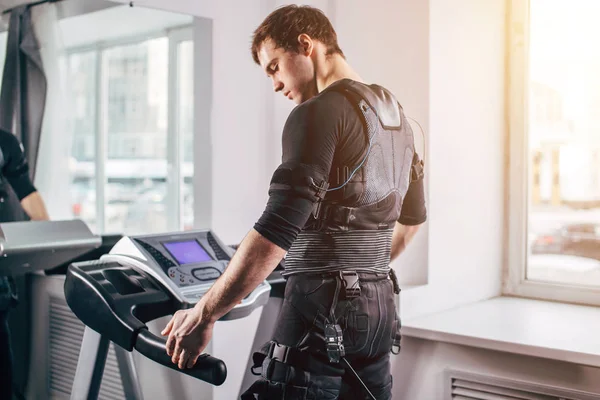 Ems eğitim salonunda treadmill çalışan siyah elbiseli adam