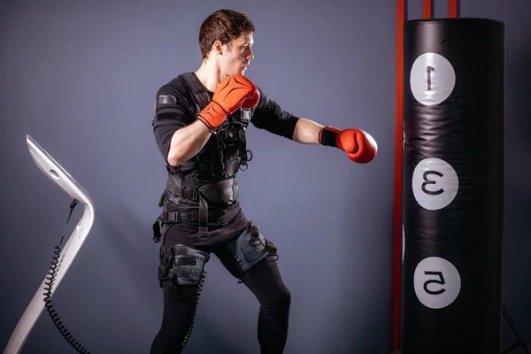 Mann in Boxhandschuhen beim Training. Boxer im Anzug der elektrischen Stimulation — Stockfoto