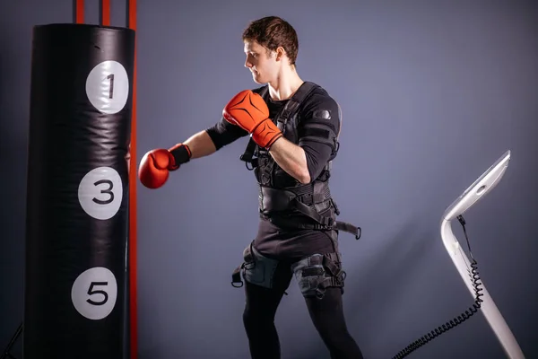 Mann in Boxhandschuhen beim Training. Boxer im Anzug der elektrischen Stimulation — Stockfoto