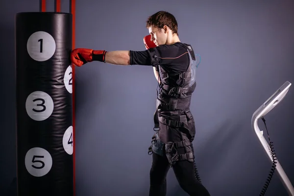 Hombre con guantes de boxeo durante el entrenamiento. boxeador en traje de estimulación eléctrica — Foto de Stock