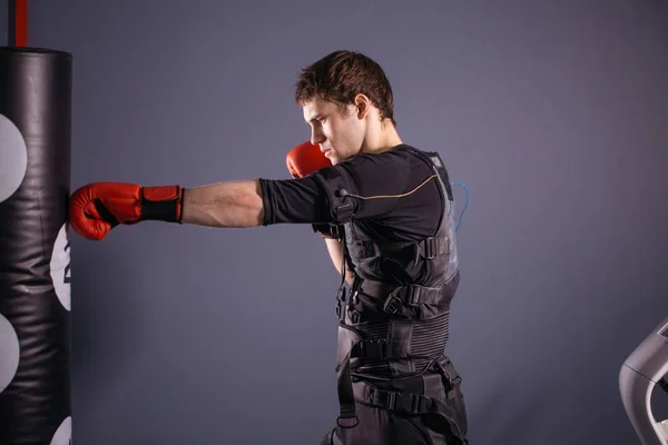 Hombre con guantes de boxeo durante el entrenamiento. boxeador en traje de estimulación eléctrica —  Fotos de Stock