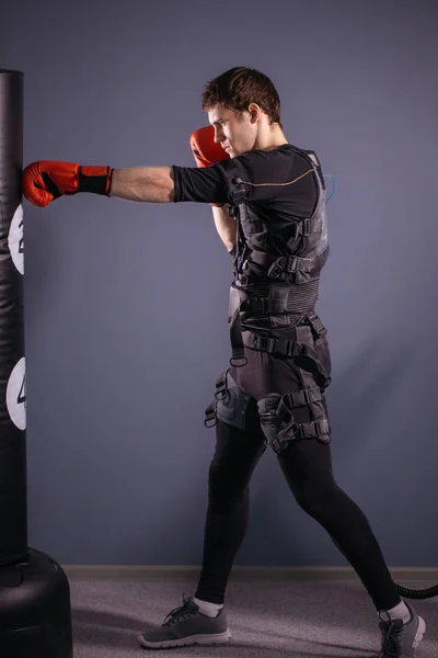 Людина в боксерських рукавичках під час тренувань. боксер в костюмі електричної стимуляції — стокове фото