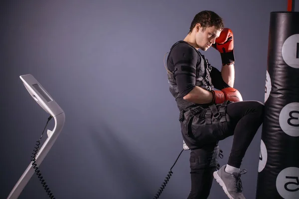Um pontapé no joelho. Um kickboxer vestindo terno de estimulação elétrica — Fotografia de Stock