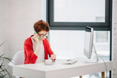 Ofisinde akıllı telefonda konuşurken işkadını