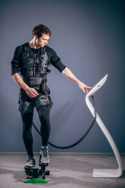 Man training on stepper with electric muscle stimulation — Stock Photo, Image