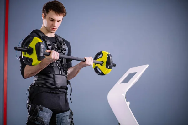 Hombre haciendo ejercicio EMS entrenamiento con barra de primer plano, pose de poder —  Fotos de Stock