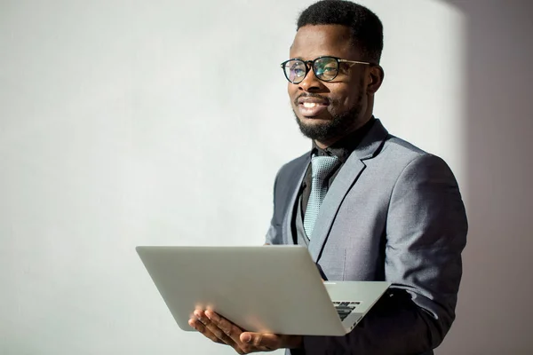 Afrikanska medarbetare bär glasögon och använder laptop i office — Stockfoto