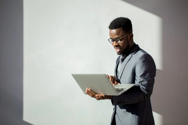 Collega africano che indossa gli occhiali e utilizza il computer portatile in ufficio — Foto Stock