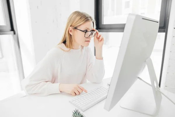 Wanita yang bekerja di kantor, duduk di meja, menggunakan komputer dan mencari di layar — Stok Foto
