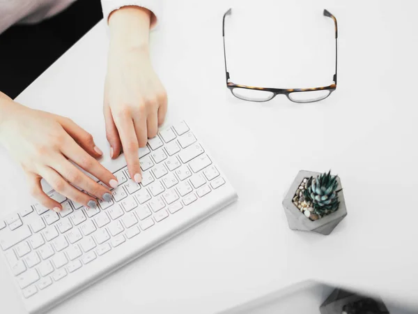 Vrouw op werkplek op kantoor typen op toetsenbord, bovenaanzicht — Stockfoto