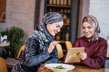 İki Müslüman kadın kafe, dükkan online elektronik tablet kullanma