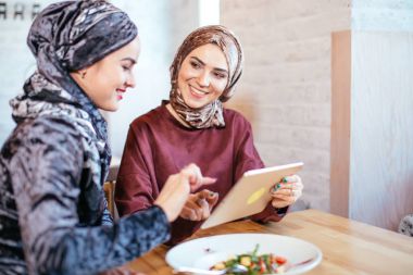 İki Müslüman kadın kafe, dükkan online elektronik tablet kullanma