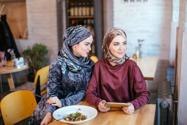 İki Müslüman kadın kafe, dükkan online elektronik tablet kullanma