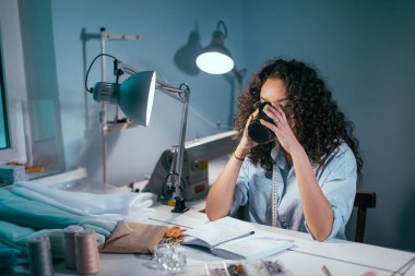Gözlüklü, atelier tabloda çay içme curlu saçlı güzel kadın