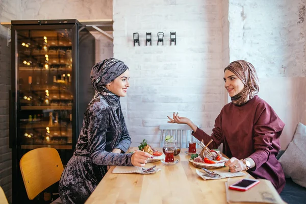 Duas mulheres muçulmanas no café, encontro de amigos — Fotografia de Stock