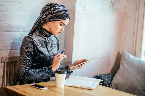 Mujeres musulmanas que trabajan con la tableta y tomar café en la cafetería — Foto de Stock