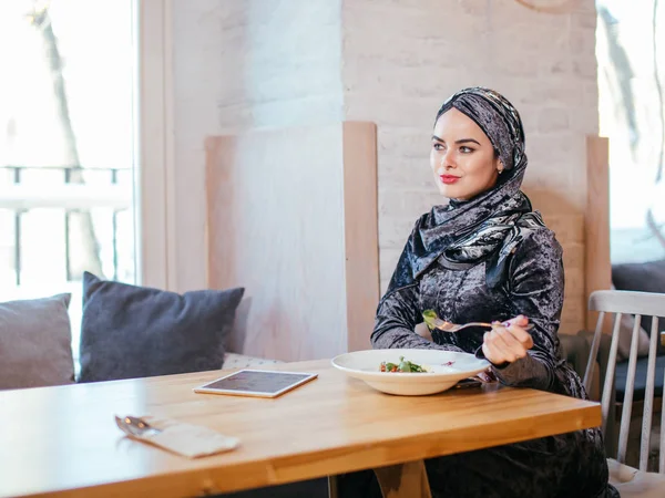 Mujer musulmana comiendo en la cafetería con comida — Foto de Stock