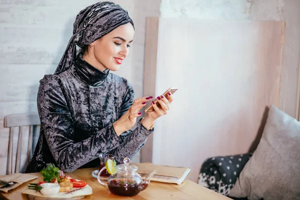 Wanita muslim memegang smartphonephone. memikirkan kenangan indah . — Stok Foto