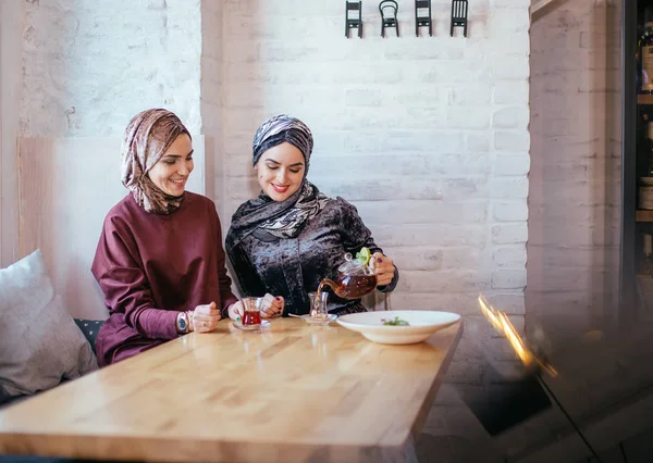 Две кавказские мусульманки пьют чай в кафе — стоковое фото
