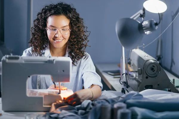 Lächelnde Näherin, die mit Heftmaschine einen Auftrag ausarbeitet — Stockfoto